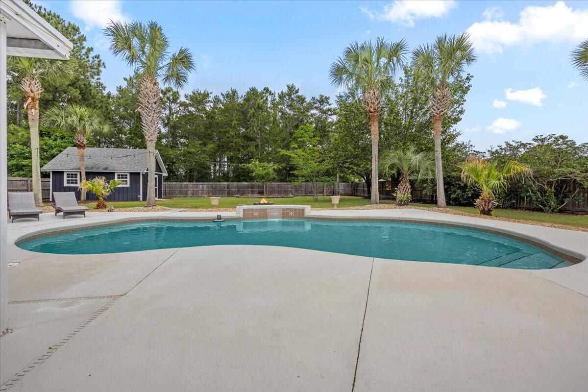 7584 Woodmont Road Navarre, FL 32566 - Photo 43 of 62 a view of a swimming pool with a yard