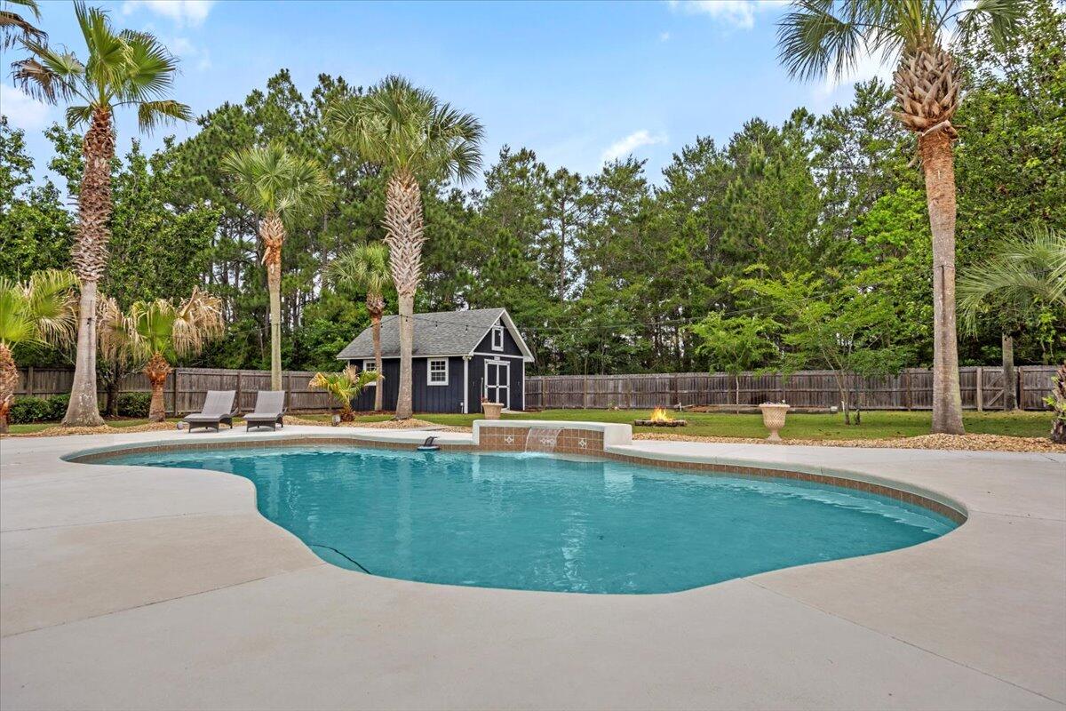 7584 Woodmont Road Navarre, FL 32566 - Photo 46 of 62 a view of a house with swimming pool and a yard