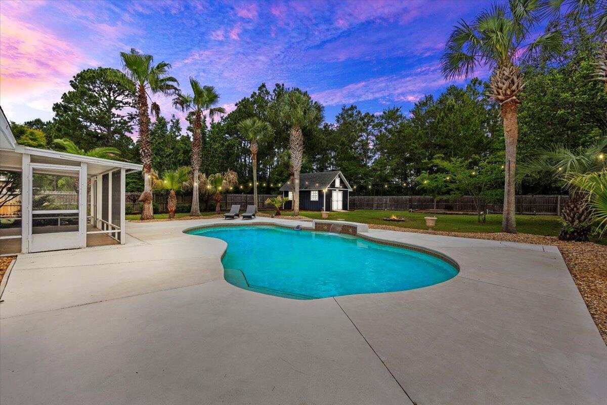 7584 Woodmont Road Navarre, FL 32566 - Photo 5 of 62 a view of a swimming pool with a house in the background
