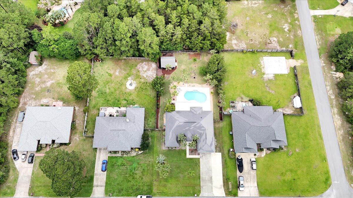7584 Woodmont Road Navarre, FL 32566 - Photo 60 of 62 an aerial view of a house with a yard and lake view
