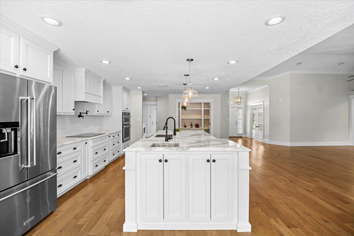 7584 Woodmont Road Navarre, FL 32566 - Photo 10 of 62 a kitchen with stainless steel appliances granite countertop a sink stove and refrigerator