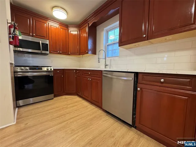 a kitchen with stainless steel appliances granite countertop a stove a sink and a microwave