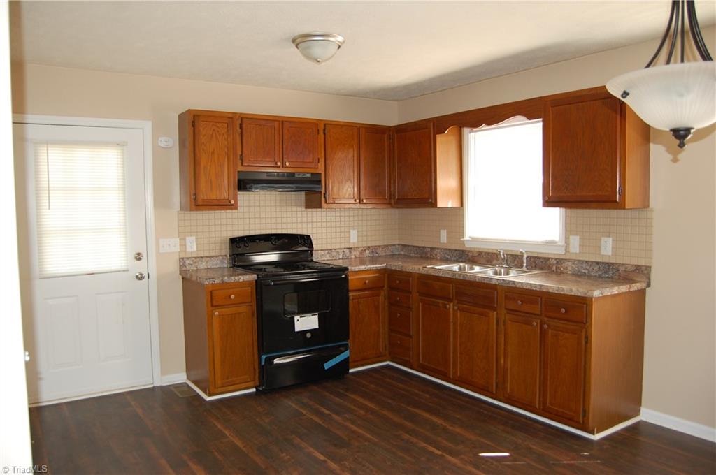 141 Maple Ridge Drive King, NC 27021 - Photo 3 of 20 Kitchen with fresh paint, laminate flooring, appliances, countertop and lighting.