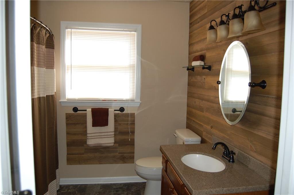 141 Maple Ridge Drive King, NC 27021 - Photo 6 of 20 Gorgeous bath remodel with new flooring, vanity top, mirror, lighting and wooden accent