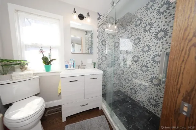 a bathroom with a granite countertop toilet sink and mirror