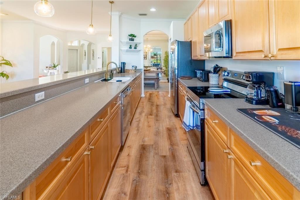 1896 Crestview Way Naples, FL 34119 - Photo 12 of 38 a view of a kitchen with kitchen island a large counter space a sink and appliances