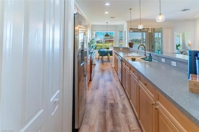 a kitchen with stainless steel appliances granite countertop lots of counter top space and wooden floor