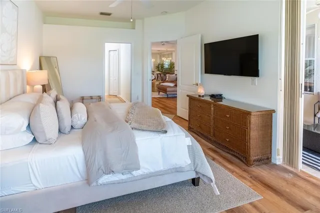a bedroom with a bed and a flat tv screen on wall
