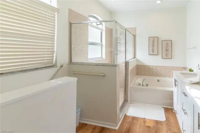 a bathroom with a tub a sink and a window