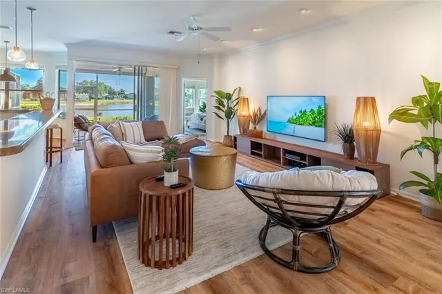 a living room with furniture a flat screen tv and a large window