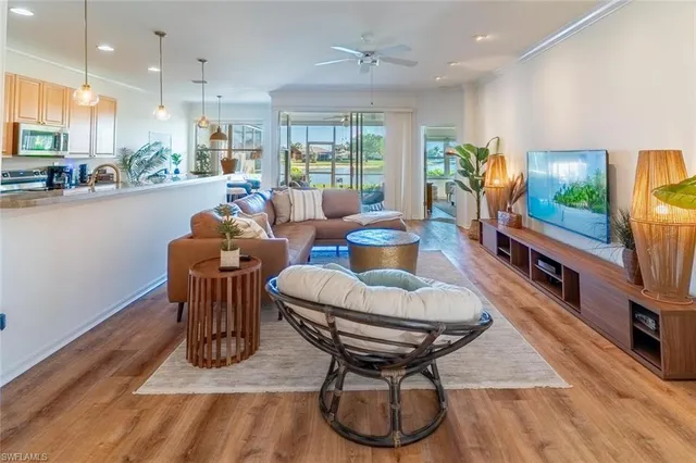 a living room with furniture a flat screen tv and a large window