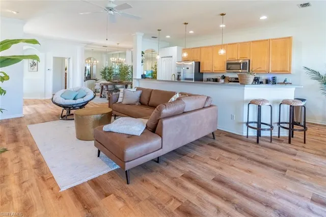 a living room with furniture a rug and kitchen view