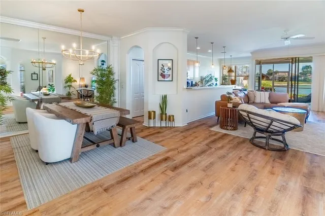a living room with furniture a rug and a dining table with wooden floor