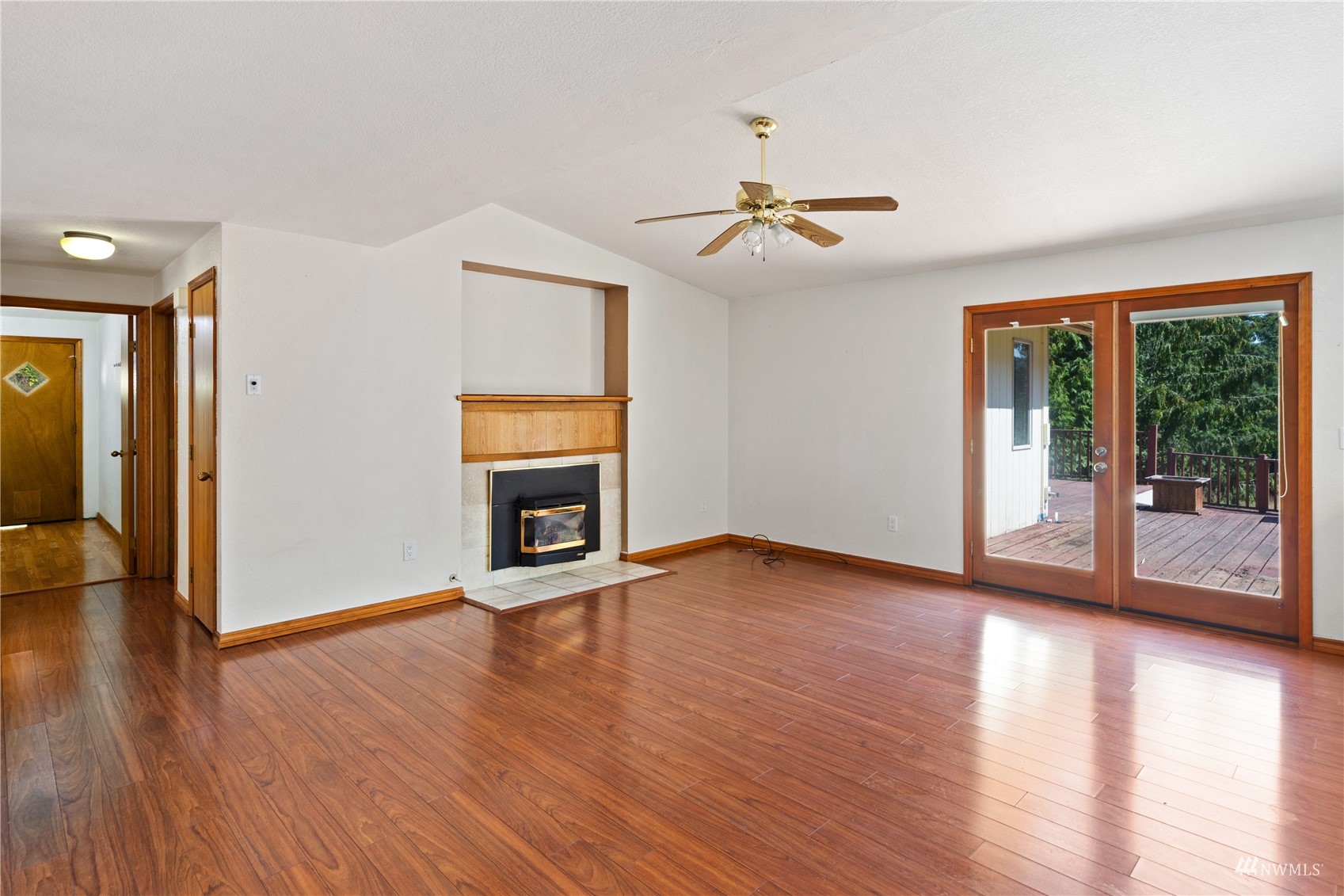 2230 West Valley Road Chimacum, WA 98325 - Photo 2 of 22 an empty room with wooden floor fireplace and windows