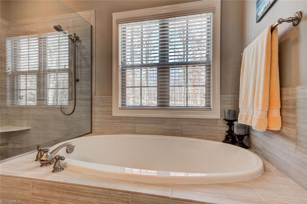 7500 Hearthridge Court Oak Ridge, NC 27310 - Photo 17 of 30 Relax in the master bedroom garden tub and walk in shower with custom tile.