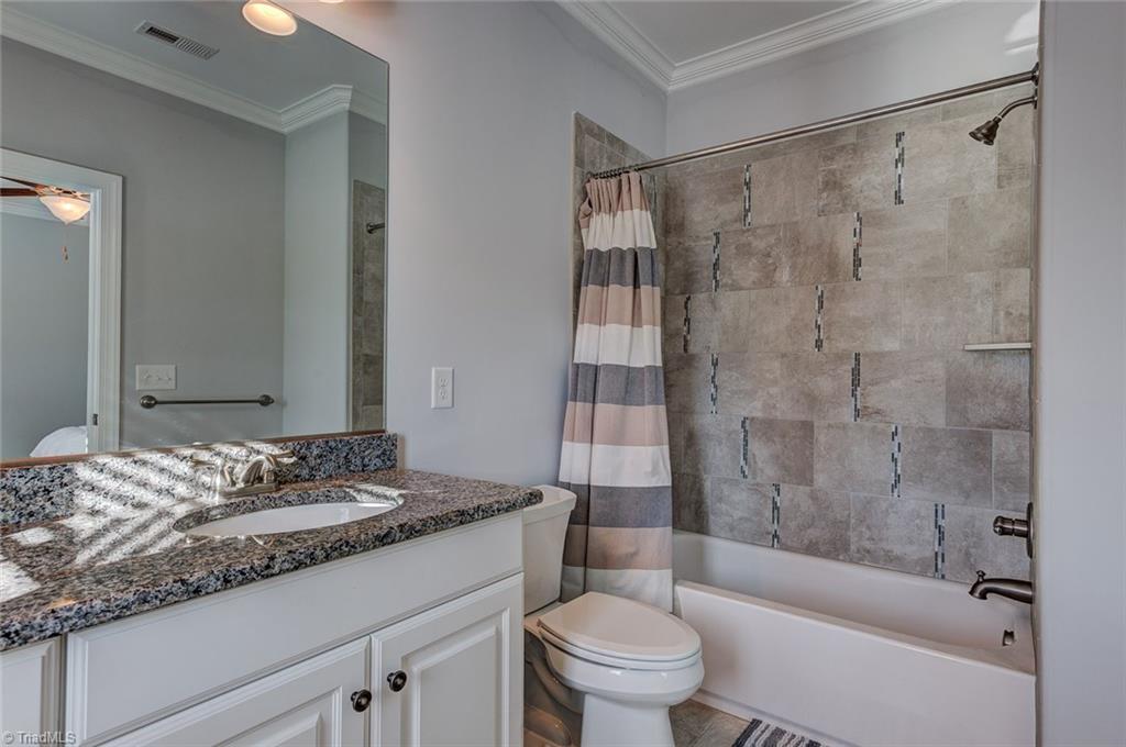 7500 Hearthridge Court Oak Ridge, NC 27310 - Photo 19 of 30 Second bedroom's private bath with granite vanity and custom tile.