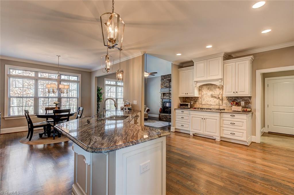 7500 Hearthridge Court Oak Ridge, NC 27310 - Photo 8 of 30 High end granite, kitchen island, breakfast bar seating, custom lighting - all contribute to this amazing home.