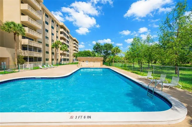 a view of swimming pool with a garden and trees