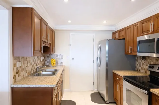 a kitchen with stainless steel appliances granite countertop a sink stove and refrigerator