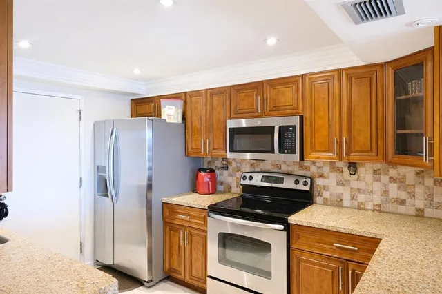a kitchen with stainless steel appliances granite countertop a refrigerator stove and sink