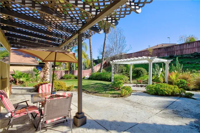 a view of a chair and tables in patio with a backyard