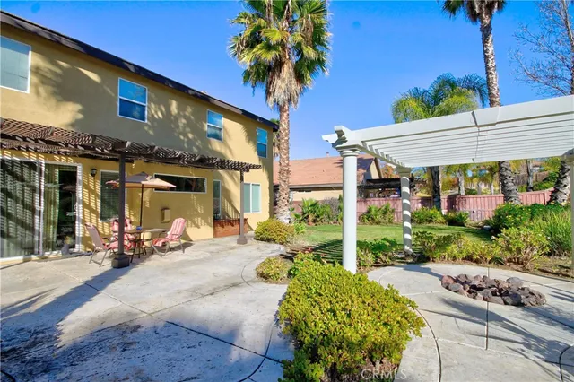 a view of a big yard with plants and a large tree