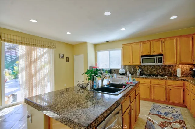 a kitchen with stainless steel appliances granite countertop sink stove and cabinets