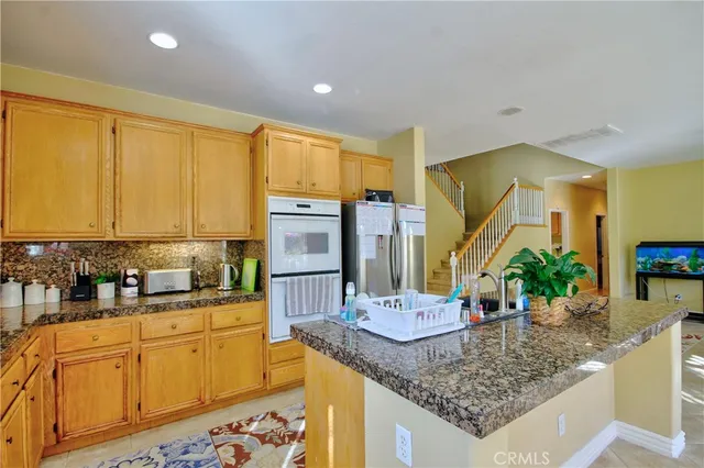 a kitchen with stainless steel appliances granite countertop a sink stove and cabinets
