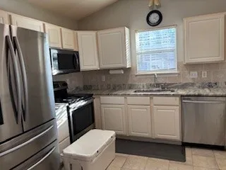 a kitchen with stainless steel appliances granite countertop a stove a sink dishwasher a refrigerator and a microwave