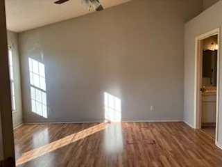 an empty room with wooden floor and windows