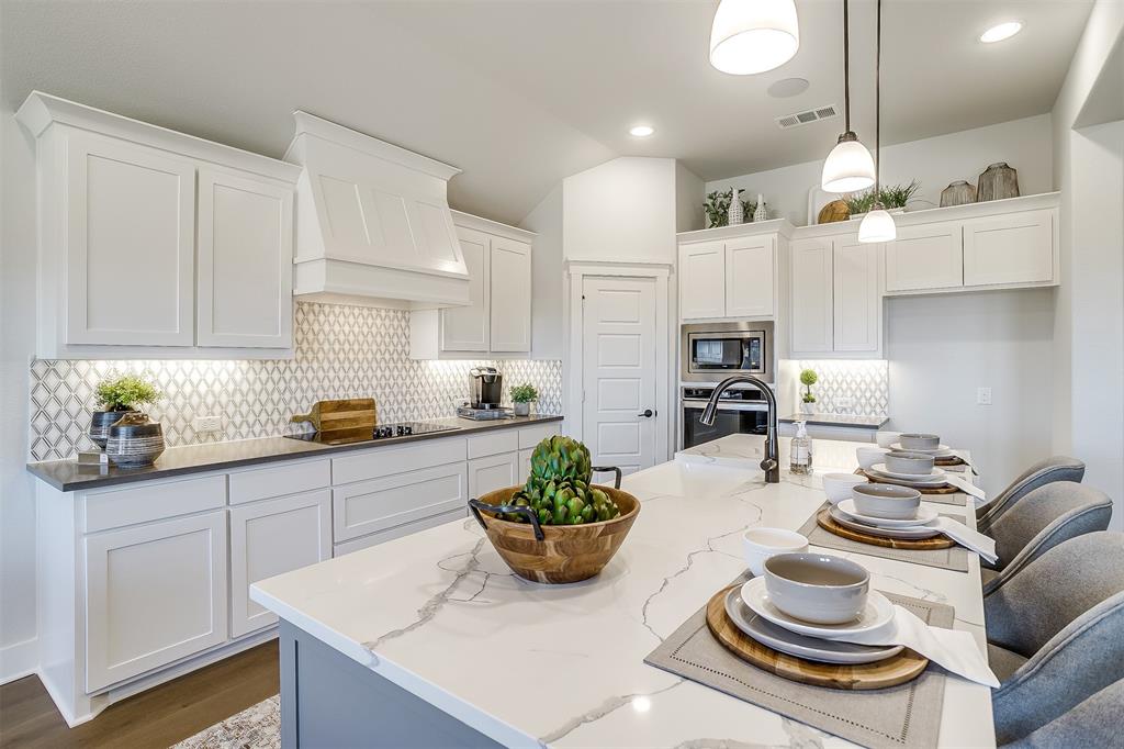 a kitchen with stainless steel appliances kitchen island granite countertop a sink and cabinets
