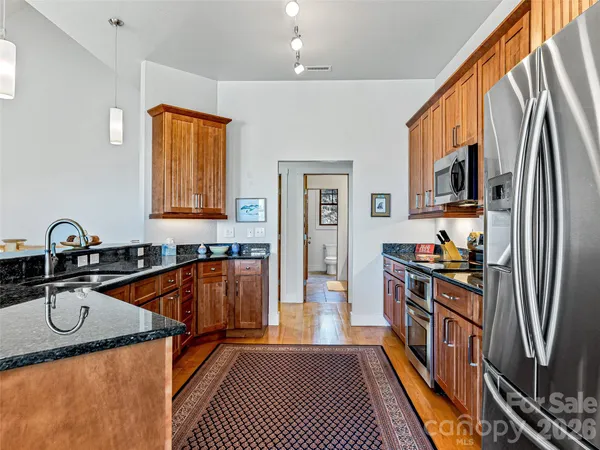 a kitchen with stainless steel appliances granite countertop a stove a sink dishwasher and a refrigerator