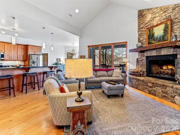 a dining room with wooden floor a chandelier a wooden table and chairs