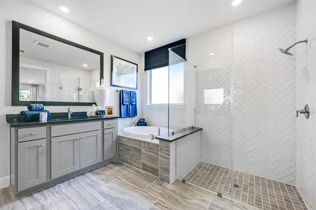 a spacious bathroom with a double vanity sink a mirror and a shower