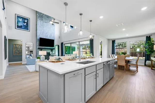 a view of kitchen island a sink wooden floor and a living room view