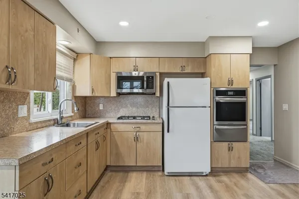 a kitchen with stainless steel appliances a refrigerator sink and microwave