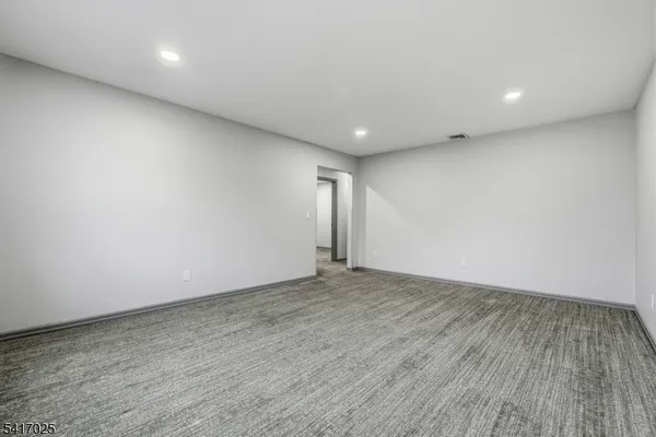 an empty room with wooden floor and natural light