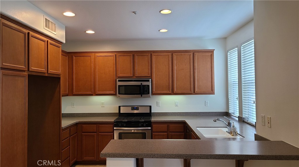 9 Garrison Loop Ladera Ranch, CA 92694 - Photo 2 of 20 a kitchen with a refrigerator a stove top oven a sink and cabinets