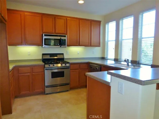 a kitchen with stainless steel appliances granite countertop a sink stove and microwave