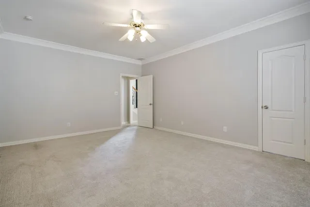 an empty room with chandelier fan