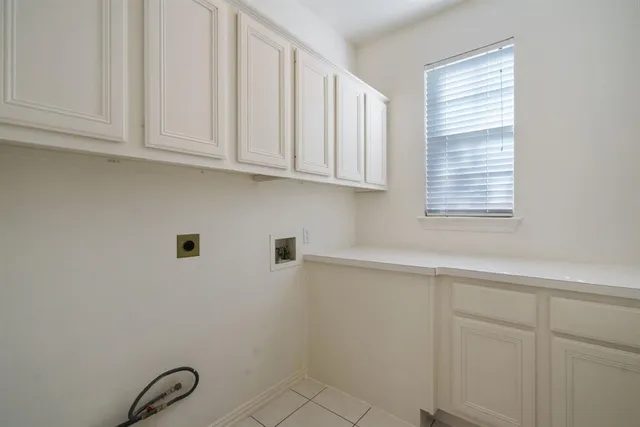 a kitchen with white cabinets and a window