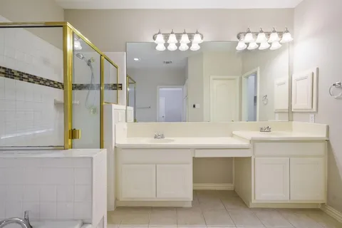a spacious bathroom with a sink a large mirror and a shower