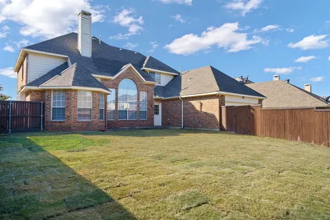 an aerial view of residential houses with outdoor space and a lake view