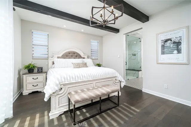 a bedroom with a bed and a chandelier