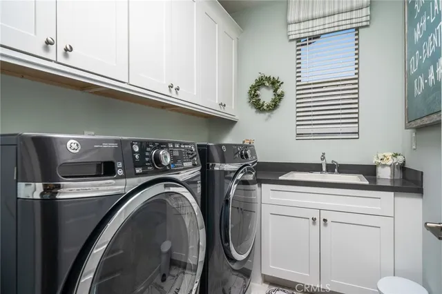 a utility room with sink dryer and washer