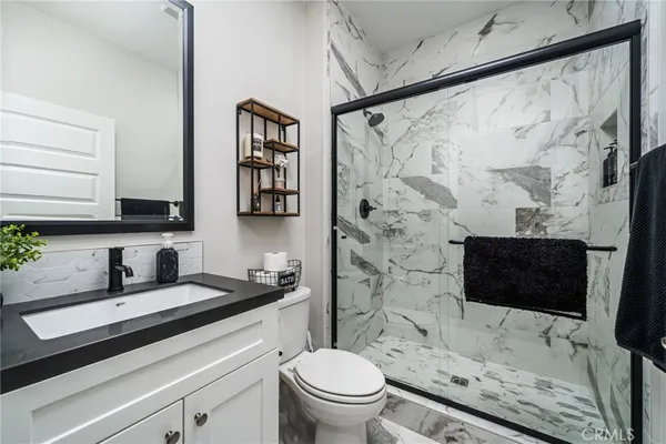 a bathroom with a sink toilet a mirror and shower