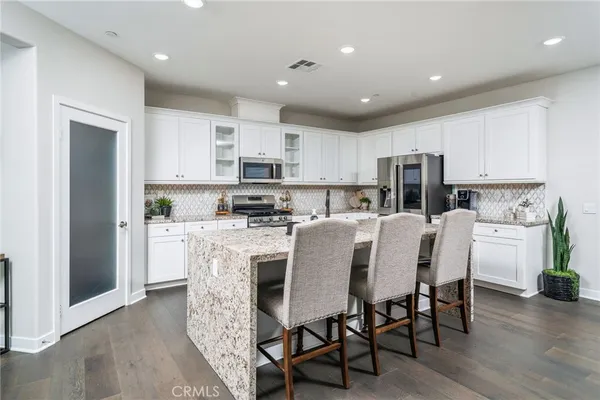 a kitchen with kitchen island granite countertop a center island stainless steel appliances cabinets and a counter top space