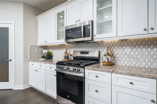 a kitchen with granite countertop white cabinets stainless steel appliances and sink