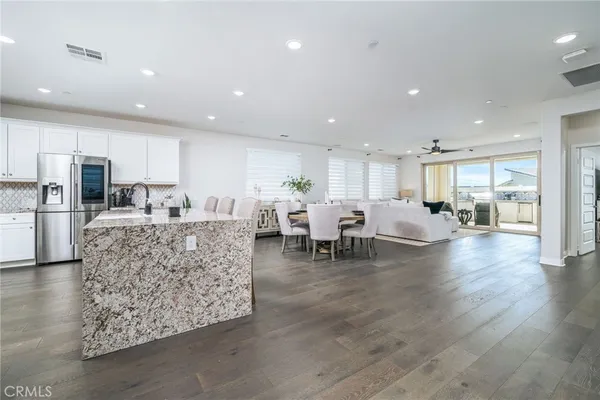 a living room with furniture and a dining table with kitchen view