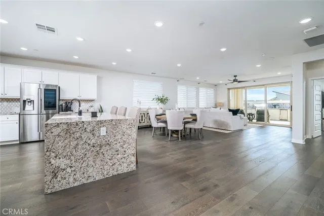 a living room with furniture and a dining table with kitchen view